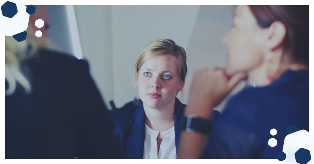 Photo showing 3 people, two from behind, one face on, engaged in an interview process