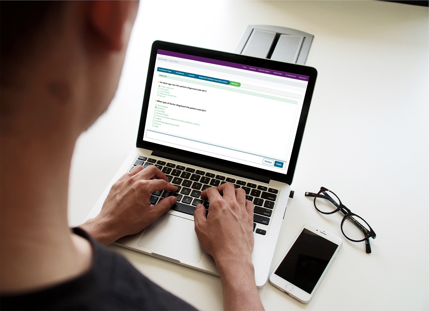 Person using registry platform to input health information via a laptop