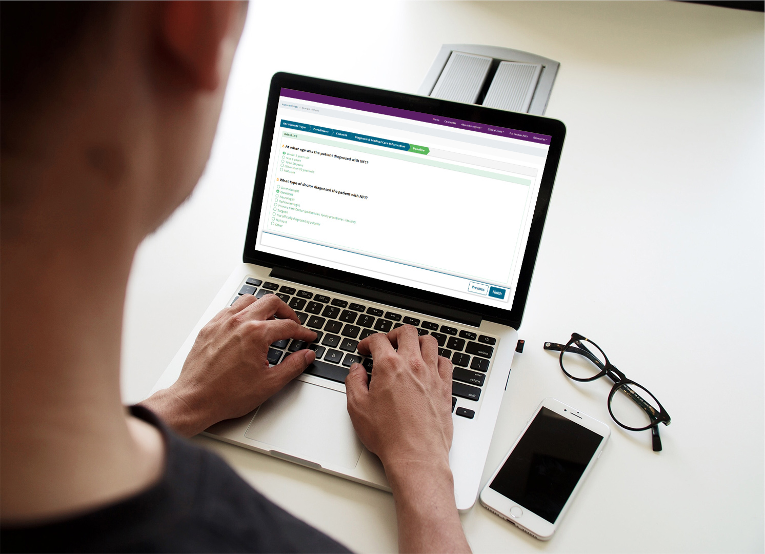 Laptop Person using registry platform to input health information via a laptop